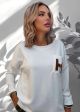 Pulovar ivory cu un buzunar decorativ IT-BL61F